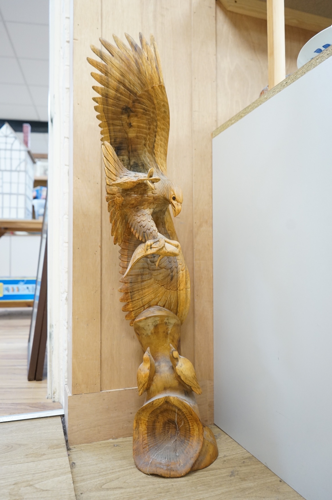 A large carved wood sculpture of an eagle and prey, 102cm high